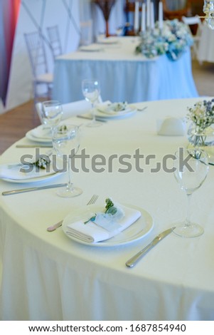 Table set with blank guest card, plate with white napkin and cutlery on table, copy space. Place setting at wedding reception. Table served for wedding banquet in restaurant