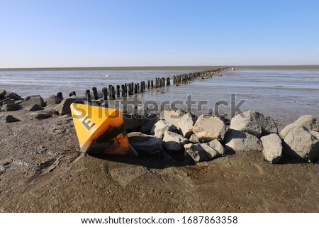 Beautiful view over the Dutch sea. It is low tide and a yellow buoy is on the bottom. Photo was taken on a sunny day with a clear blue sky.