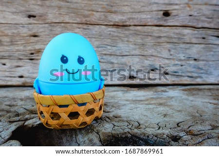 Happy Easter with the cute easter eggs that are symbolic on a wooden background.