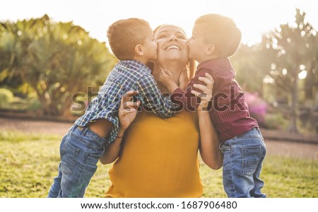 Happy mother having fun with her two sons playing outdoor - Love and family concept - Focus on mother face Royalty-Free Stock Photo #1687906480