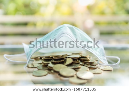 Money, Business, Healthcare in Cornavirus (COVID-19) Situation Concept. Pile of gold coins under surgical face mask with copy space. Royalty-Free Stock Photo #1687911535