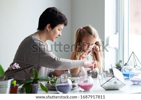 Woman teaches planting succulents in a glass florarium at a lesson in a creativity studio,indoor