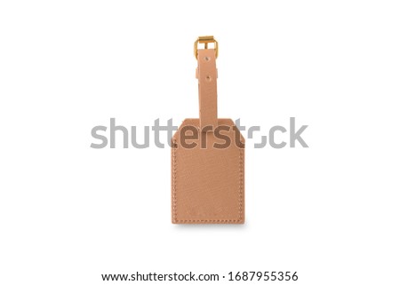 A close view of a beige leather name tag with a belt for luggage isolated on a white background.