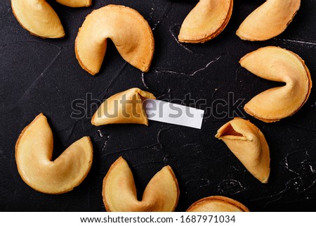 Fortune cookies on a black background, close-up. Royalty-Free Stock Photo #1687971034