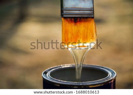 Close up of varnish dripping of paint brush. Brush with lacquer over can, nobody Royalty-Free Stock Photo #1688010613