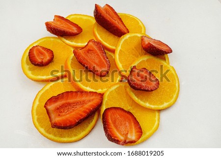 Halves of strawberries lie on pieces of orange fruits. Products to enhance immunity