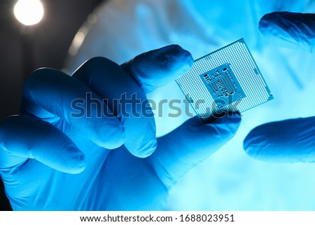 Close-up gloved hands holding detail microchip. Man in special uniform shows microprocessor chip. Production technology hitech. Repair microprocessor electronics electrical equipment. Royalty-Free Stock Photo #1688023951