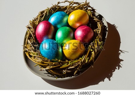 Colorful easter eggs in nest on white background.