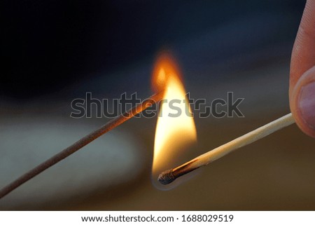 Lighting a joss stick with a match