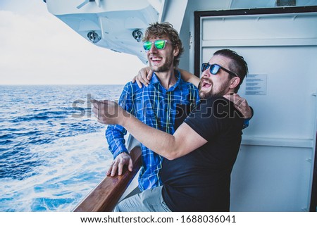 
two men on the balcony of a cruise ship