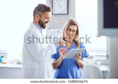 A dentist with dental assistant in modern dental surgery, working. Royalty-Free Stock Photo #1688036674