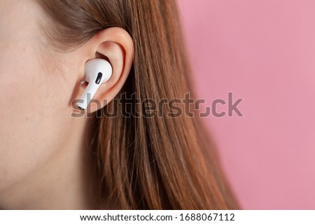 girl uses wireless white headphones on a pink background. Air Pods Pro. with Wireless Charging Case. New Airpods pro on pink background. Airpodspro. female headphones. apple headphones.EarPods Royalty-Free Stock Photo #1688067112