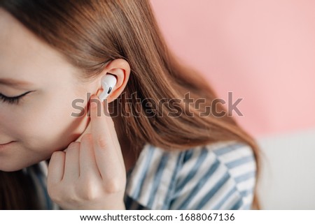 girl uses wireless white headphones on a pink backgroundюAir Pods Pro. New Airpods pro on pink background. Airpodspro. Royalty-Free Stock Photo #1688067136
