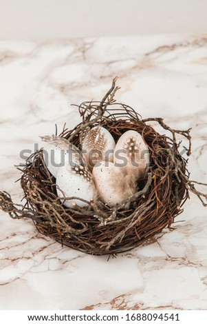 Bird's nest and decorated Easter eggs on a marble background