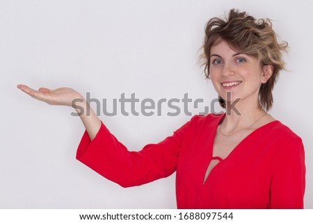 Your text here. Pretty young excited woman holding empty blank board. Colorful studio portrait with pink background.