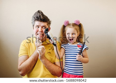 Daughter makes dad a new hairstyle and have fun  Royalty-Free Stock Photo #1688098042