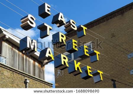The yellow sign hanging above the East Street Market, a a street market in Walworth, South London, which is also known as 'The Lane', or 'East Lane'.  Image has copy space.
