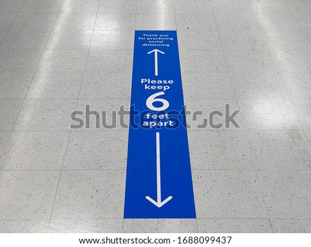 Social distancing floor sign warning about safe distance between people of 6 feet. Public health measure to prevent further spread of new corona virus Covid-19 infections.