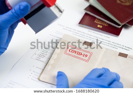 COVID-19 stamped passport ID,airport border customs health and safety security check,restrictive no entry measures due to SARS-CoV-2 corona virus disease epidemic,Coronavirus global pandemic,US  UK  Royalty-Free Stock Photo #1688180620