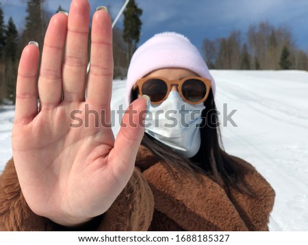Girl, young woman in protected sterile medical mask on her face, looking at camera outdoors in large size. Crown pandemic virus. Beautiful brunette girl with medical mask.