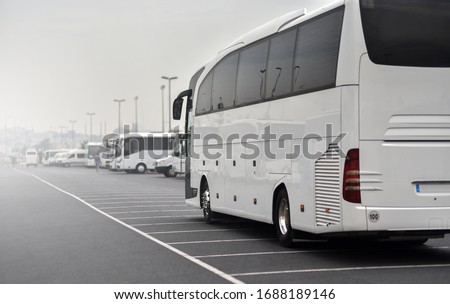 large tour bus rides along parked minibuses Royalty-Free Stock Photo #1688189146
