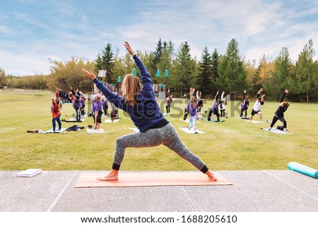 Yoga classes outdoors. Group of adults attending yoga classes in the park. Healthy lifestyle. Being healthy in body and mind Royalty-Free Stock Photo #1688205610