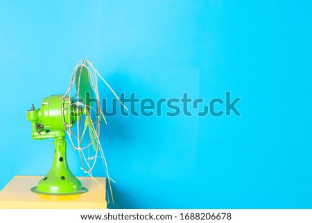 Antique green colored fan with blue background