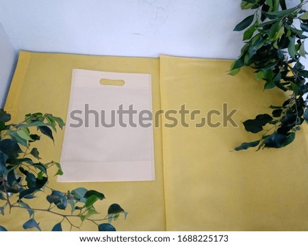 Light Yellow Color D Cut Bags isolate on yellow fabric background. Luxury Shopping Bags. Copy space for text and Logo Concept. 