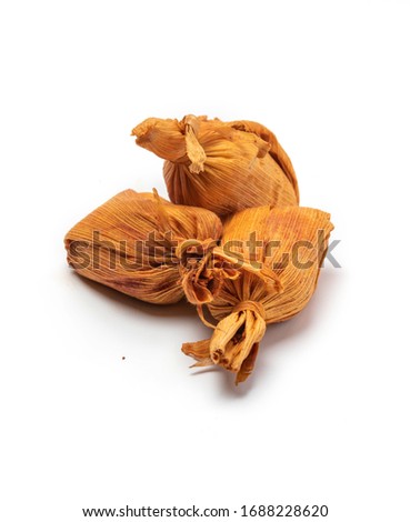 Latin american traditional snacks made of corn,  (called "chuchitos") wrapped with dry leaf isolated on white background
