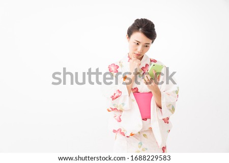 attractive asian woman wearing traditional Japanese casual summer kimono called "Yukata",smart phone,think,