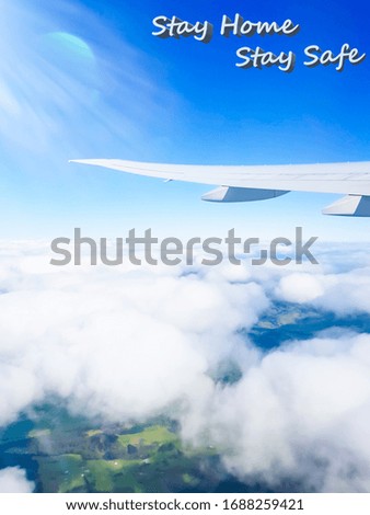writing on airplane wing Stay Safe with clouds and landscape background