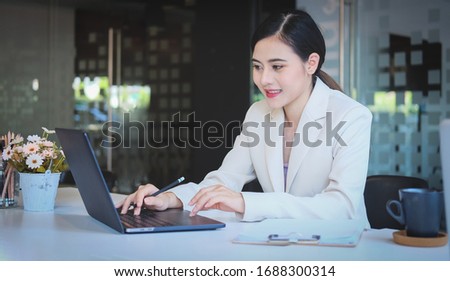 Concept business woman working and people happy businesswoman or creative female office worker with computers writing to notebook with documents and laptop.
