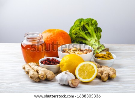 Food for immunity stimulation and viruses protection. Broccoli, citrus fruits, honey, ginger, lemon, garlic, goji, turmeric on white wooden background. Healthy natural food to boost immune system
 Royalty-Free Stock Photo #1688305336