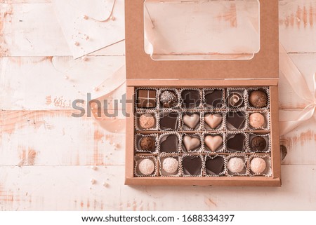 Box with delicious candies on white wooden background