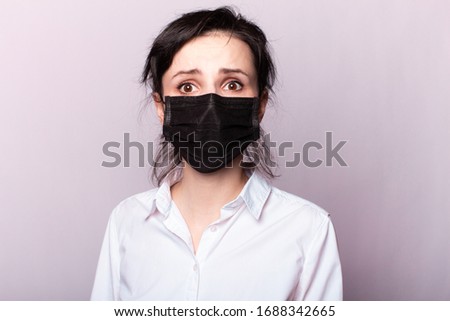beautiful girl in a white shirt and black medical mask
