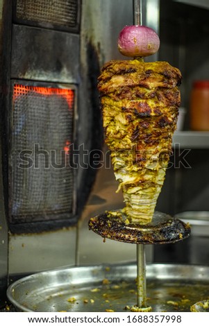 Fresh shawarma with tray full of shawarmas. Shawarma is one of the most popular fast food dish in Asian and Middle Eastern Countries.Closeup picture of stacked meat roasting chicken shawarma