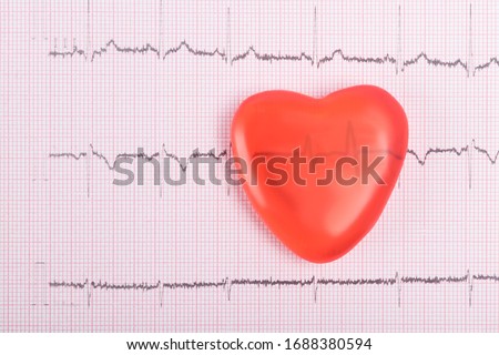 red heart on a paper cardiogram background, top view, close-up