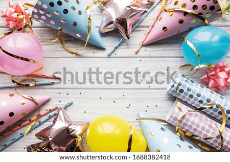 Happy birthday or party background.  Flat Lay wtih birthday hats, confetti and ribbons on white wooden background. Top View.  Copy space.