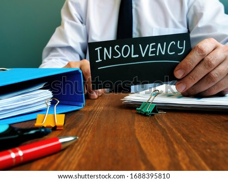 Man holds sign insolvency about company bankruptcy. Royalty-Free Stock Photo #1688395810