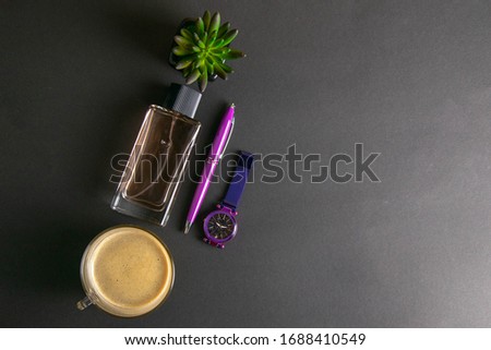 Women's parfums together with coffee with milk and green flower, next to there are purple watches and a pen top views with clear space