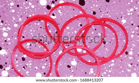 Red rubber band on concrete with circular polka dots