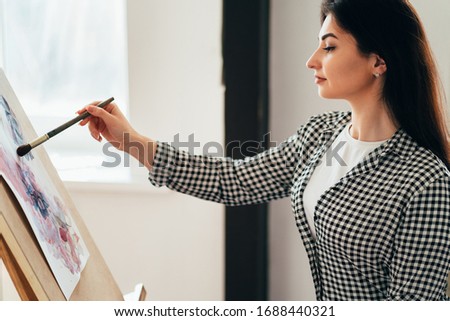 Creative hobby and leisure concept. Young woman painting with watercolor at home studio