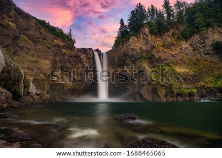 Long exposure photo of a pink sunset at golden hour in Snoqualmie Falls in Washington state, the Pacific Northwest, a landmark near Seattle. Beautiful Background wallpaper.