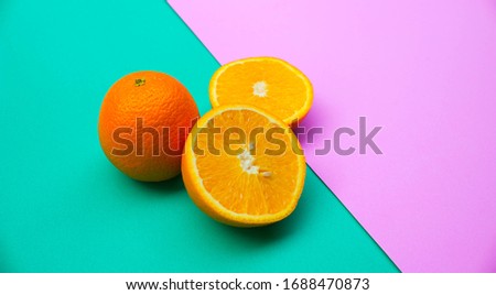 Bright orange fruit, round shape with orange skin arranged on a strange colorful background paper