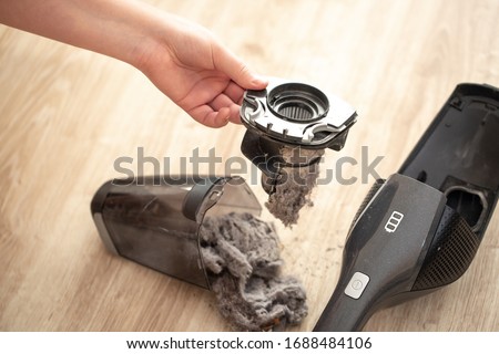 Close up of massively clogged, dirty filter of hand vacuum cleaner, dust and powder on the vacuum filter, household Royalty-Free Stock Photo #1688484106