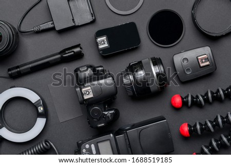 Modern photographer's equipment and card on dark background