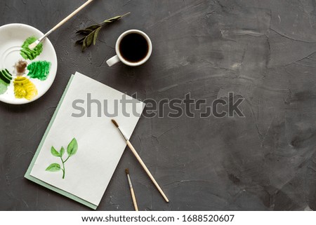 Drawing plants. Brushes and picture on grey background top-down copy space