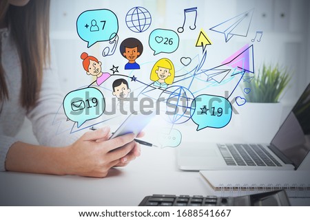 Unrecognizable young businesswoman working with smartphone in blurry office with double exposure of creative and bright social media sketch. Concept of communication. Toned image