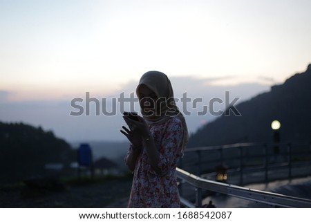 silhouette hijab girl with smartphone on park. silhouette muslim girl with phone