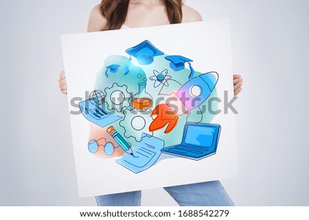 Unrecognizable young woman with long dark hair holding poster with colorful education sketch drawn on it. Concept of knowledge and graduation